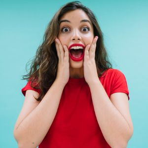 A surprised and excited woman wearing a red dress